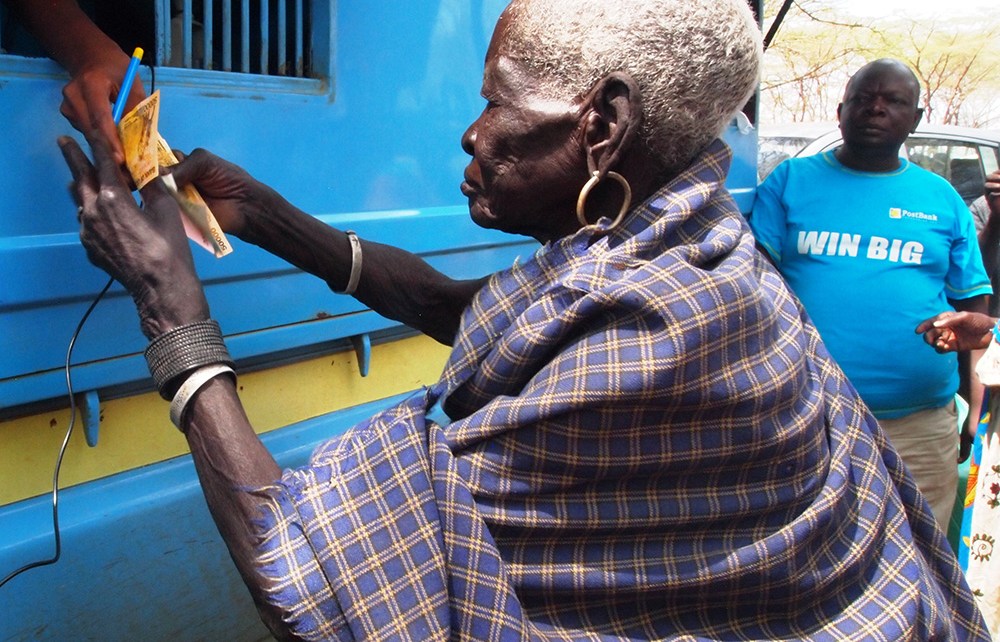 Teko Okudo recieving money from the mobile bank van in Moroto