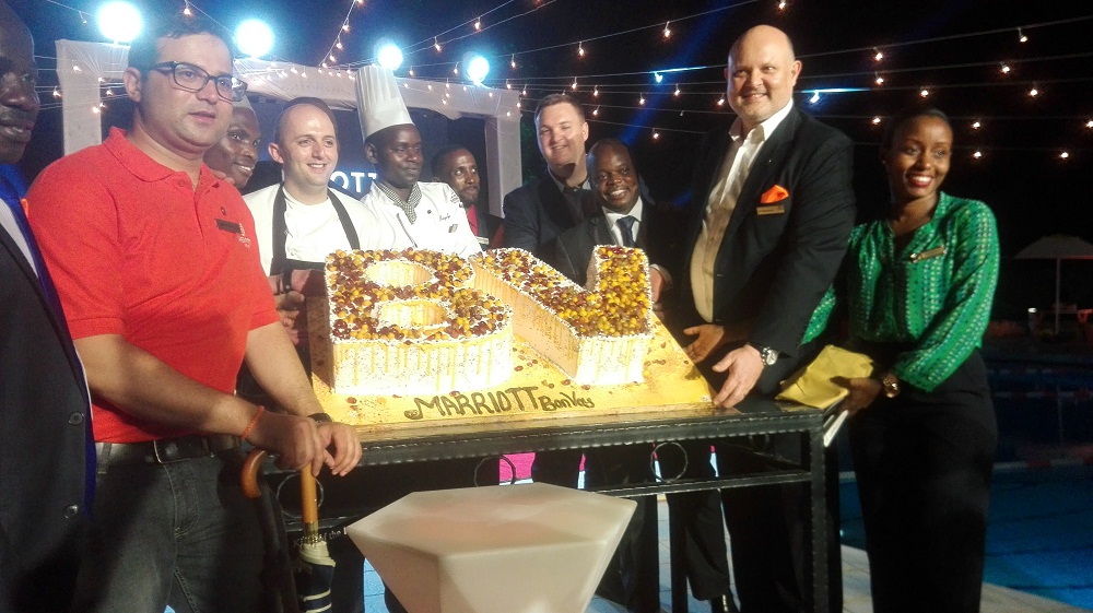 Staff of Sheraton Kampala Hotel displaying the Marriott Bonvoy launch Cake.