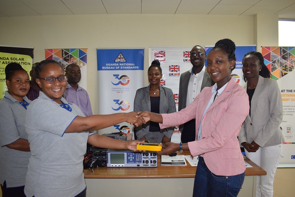 UNBS acting Executive Director Patricia Ejalu (Left) receiving the gadgets from DFID Programme Manager Lydia Nandawula during the event