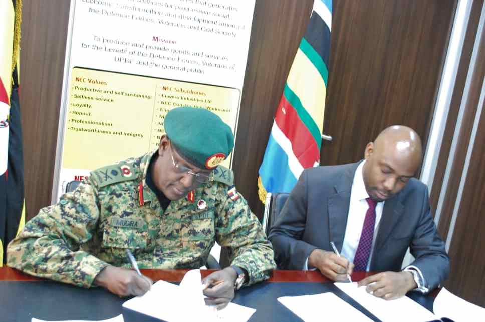 Managing Director of NEC, Lt Gen. James Mugira, (Left) and Executive Director of UFZA Richard Jabo (Right) pens down the deal at NEC offices in Bugolobi, Kampala recently