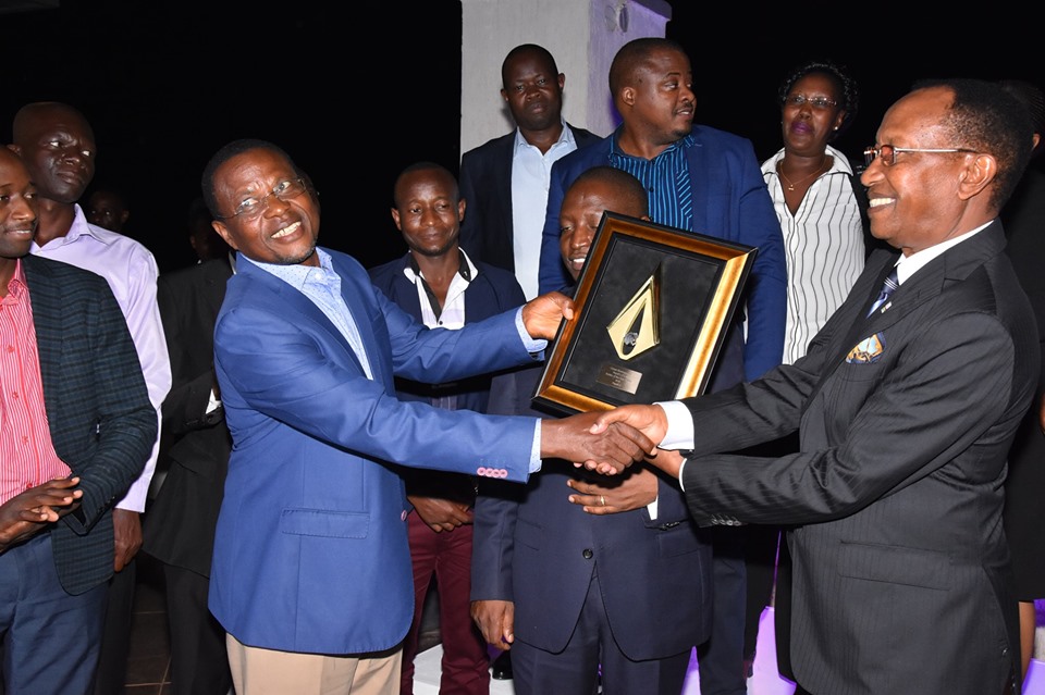 Crown Beverages CEO Mr. Paddy Muramirah (left) and Chairman Board of Directors Mr. Amos Nzeyi (Right) show the ESSA Bottler of the year award to the directors and partners at the celebratory dinner at Windsor Apartments-Kololo on Thursday, 11th July 2019.