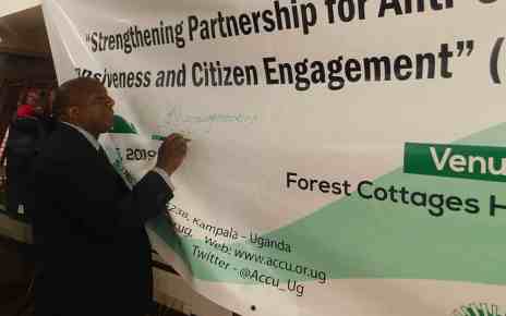 The Deputy Inspector General of Government George Bamugemereire signing on the project banner as sign of commitment to support the project