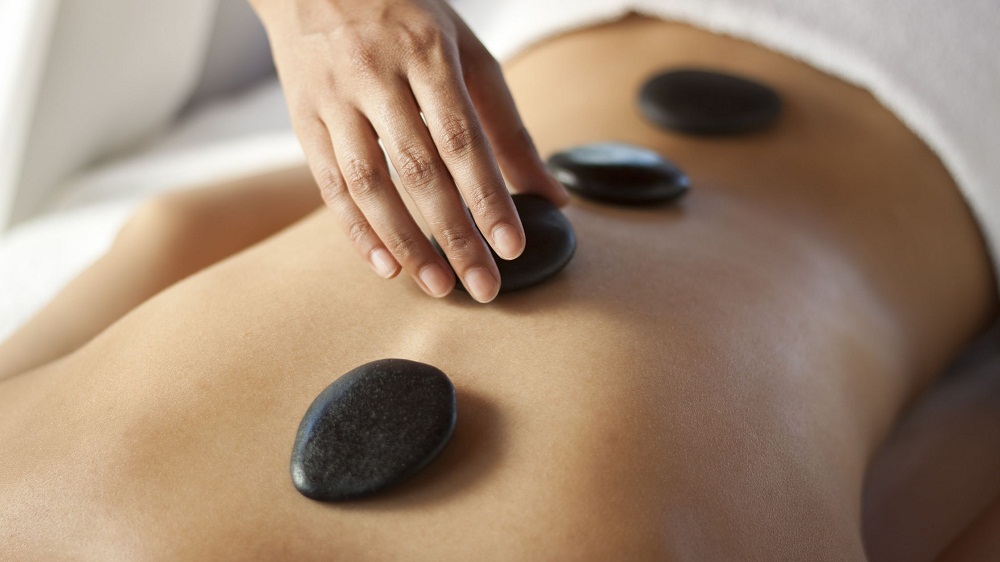 A hot stone massage is a type of massage therapy. It’s used to help you relax and ease tense muscles and damaged soft tissues throughout your body.